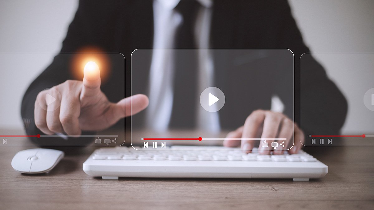 One person with white keyboard and mouse in front and touching on some technology